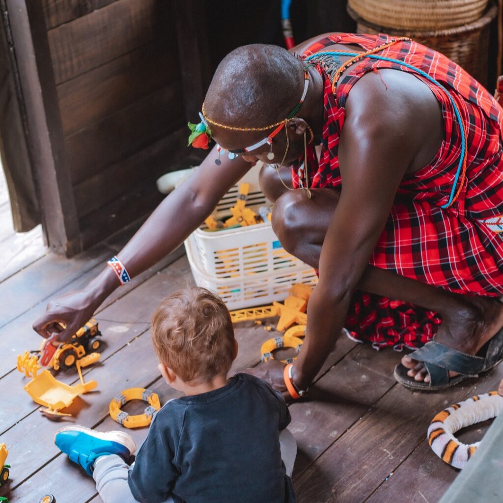 a kid playing with a maasai guide at mara Bush Camp in masai mara