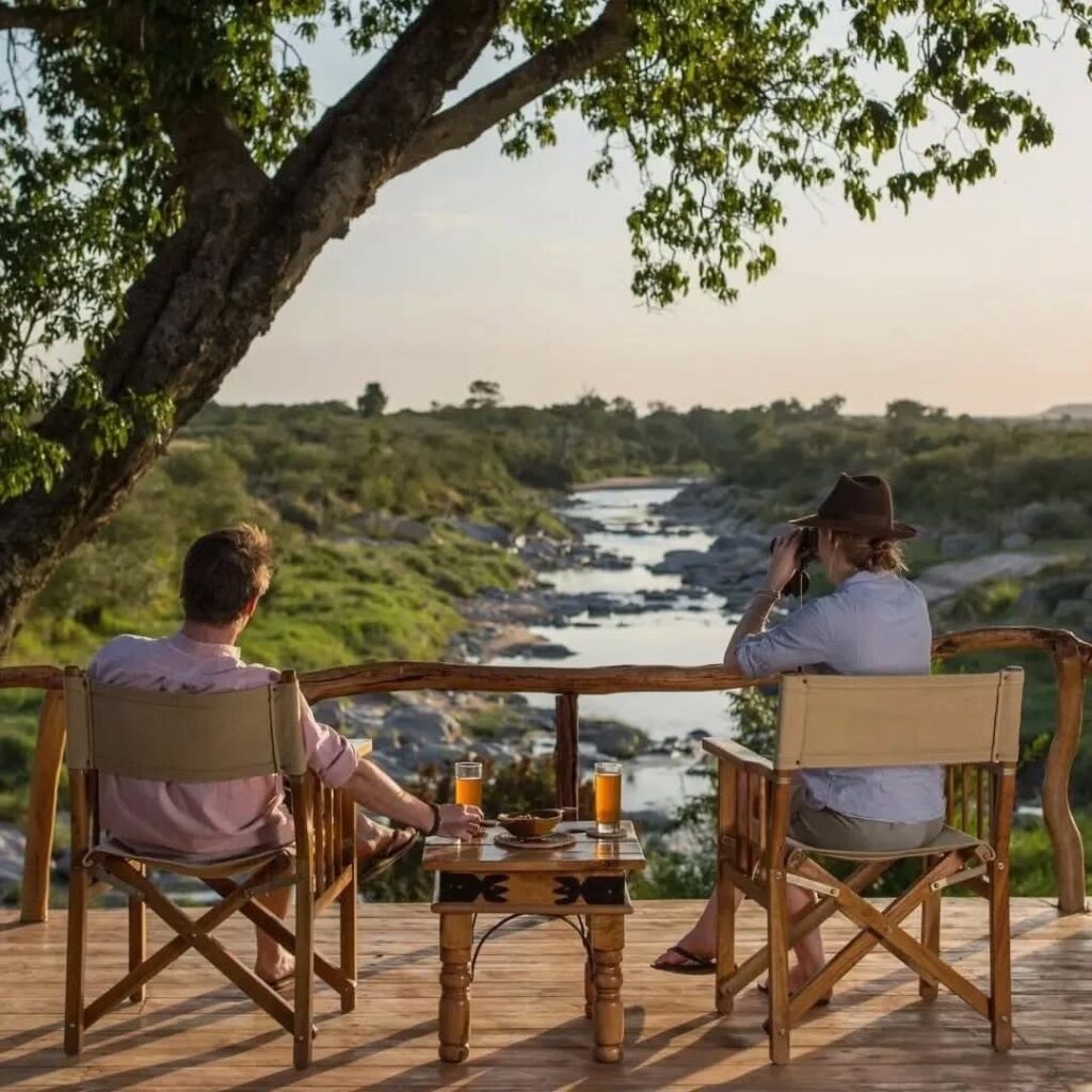 tourists enjoying their evening gazing at the mara river from Rekero Camp