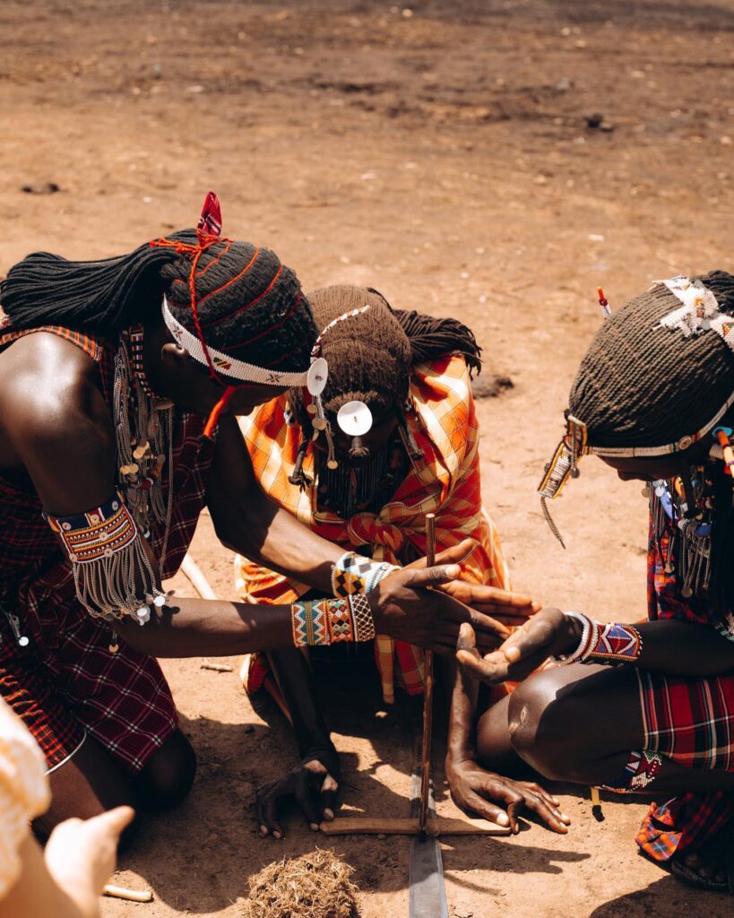 maasai warriors making some fire using firewood in a traditional way