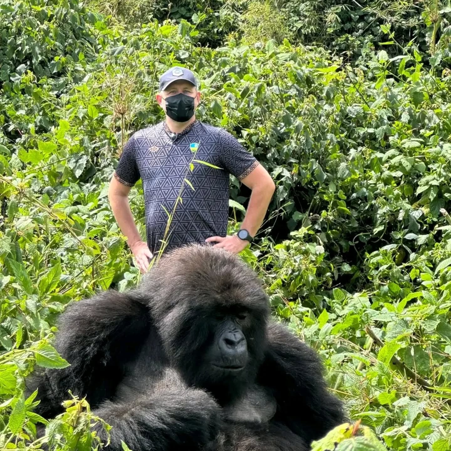 a tourist posing for a photo at Volcanoes National Park during his gorilla trekking safari in Rwanda